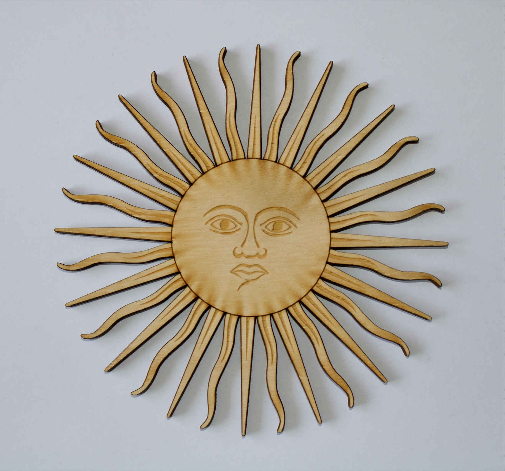 A sun printed with laser on wood.
