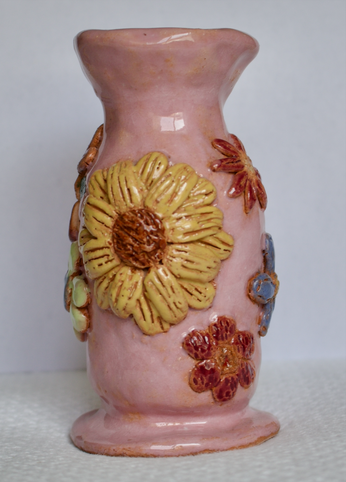 A pink ceramic flower vase with a ceramic flowers texture.